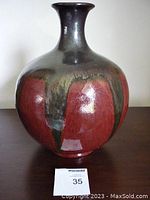 Front view of the signed studio ceramic vase, showing bulbous shape and color glaze pattern.