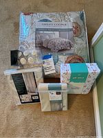 Items include Ashley Cooper twin comforter with beach-themed seashell and coral design, twin sheets with cherry pattern, and new shower curtain set with liner and holders.
