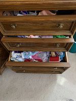 Top three drawers of oak dresser showing mixed contents