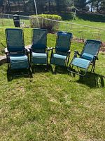 Four chairs upright on lawn, front view