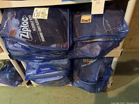 Four blue Ziploc flexible storage bags containing assorted holiday decorations placed on a basement shelf
