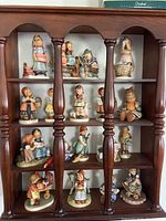 Full shelf view showing all 16 figurines arranged in four rows