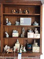 Wooden four-shelf unit with assorted porcelain figurines and boxed pieces