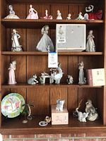 Four-tier wooden shelf displaying porcelain figurines and decorative items