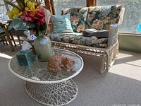 Front view of loveseat glider and coffee table with décor items arranged