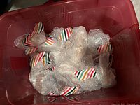 Bin of 16 bubble-wrapped assorted porcelain figurines in red plastic storage bin
