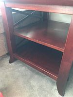 Close-up of the lower shelf area showing the legs and wood veneer finish.
