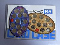 Photo showing both coin sets, 1999 on gold background, 2000 on blue background in oval display cases