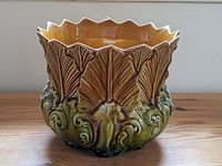 Front view of ceramic planter showing scalloped rim and detailed leaf relief