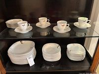 Photo showing large plates, small plates, and saucers stacked. Some plates have chips visible on edges.