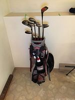 Full view of golf bag upright with multiple golf clubs and headcovers visible