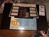Box showing closed wooden art case packaging with printed image of contents and pieces count.