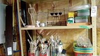 Shelf holding various paintbrushes in containers, colorful baskets, and packaging for sheet protectors and foam blocks.