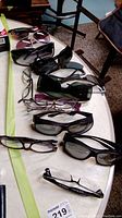 Overview photo showing all 8 pairs of glasses of various styles including prescription and sunglasses laid out on a table