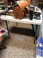 Full view of the utility table with resin top showing miscellaneous items placed on top and carpet flooring beneath.
