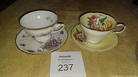 Top view of two cups and saucers showing floral designs on each piece
