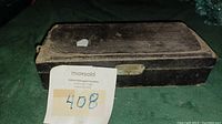 Old black rectangular carry case closed, worn with age and use