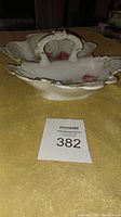 Top side view of the vintage divided porcelain serving dish showing floral design and scalloped edges with gold trim