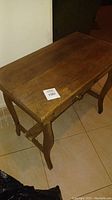 Photo of the old small wood student desk showing the surface and legs.