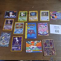 Overhead photo of all Pokémon cards including Mewtwo, Machamp, Jumpfluff, Charmeleon, and Haunter promotional booklet.