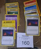 Photo showing a group of Pokémon Trainer and Energy cards, including Energy Search, Full Heal, Skull Fossil, and various energy types.