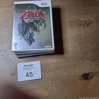 Photo of The Legend of Zelda Twilight Princess game case for Wii on wooden surface, showing the front cover with clear visible artwork and title.