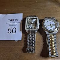 Photo showing two older wristwatches on a wooden surface, one square with crystal bezel and three subdials, the other round with two-tone bracelet and day-date feature