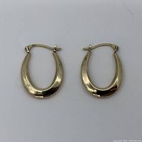 Pair of 10K gold hollow hoop earrings front view on white background.