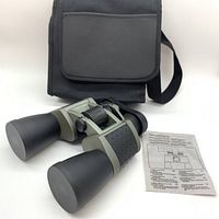 Photo showing binoculars with rubber lens covers, carrying case and instruction sheet arranged on white background.