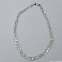 Clear quartz necklace laid out flat showing graduated faceted beads and silver clasp.