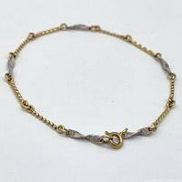 Photo showing full bracelet laid flat, highlighting bi-colour gold segments and clasp.