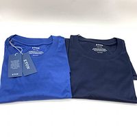 Two folded Eton crewneck t-shirts laid side by side, royal blue with tags and navy without tags.