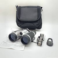 Binoculars, multitool, compass, and carrying bag displayed together with instruction manual visible.