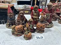 Full group of 8 varied Tom Clark figurines including several gnome/Halloween pumpkin themed pieces, teddy bear, and grandmother figures on a table.