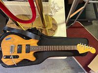 Full front view of guitar laid on gig bag with strap visible