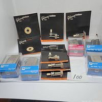 Photo of various Gibson Pure pickups, toggle switches, and Seymour Duncan Hot Rails pickups along with other small guitar parts in packaging