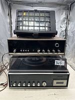 Front view of the Concord amplifier with wood finish and control panel, speaker with black grill on top, and record player with dust cover at the bottom.