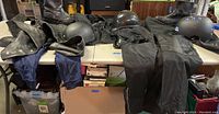 Overview of motorcycle gear laid out including jackets, pants, boots, and four helmets.