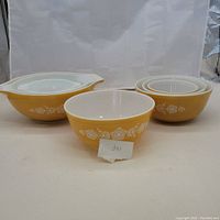 Full set of 7 Pyrex mixing bowls in Gold Butterfly yellow pattern with white interior shown together.