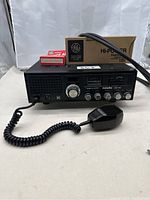 Front view of Realistic Navaho CB radio with microphone attached and flashcube boxes on top