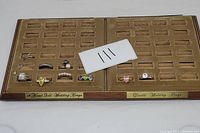 Lot of rings arranged in a vintage display case labeled for 14 karat gold and duette wedding rings, but containing 9 rings mostly sterling silver and costume rings.