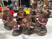 Six Tom Clark Santa figurines grouped together, showing size and variety.