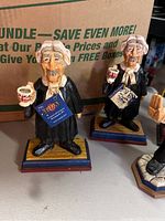 Close-up of two judge figurines holding teacups labeled 'Charles I' and 'Charles II' from David Frykman English Collection.