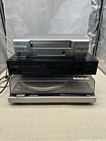 Stacked view of Sanyo VCR (top), Denon CD player (middle), and Technics SL-Q2 turntable (bottom)