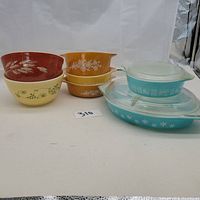 Full view of all Pyrex bowls and casseroles arranged showing varied patterns and glass lids