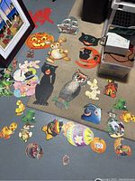 Vintage paper holiday decorations displayed on floor showing various animals, characters and themed cutouts including Halloween pumpkins, rabbits, cats, owls, Easter eggs and leprechauns.
