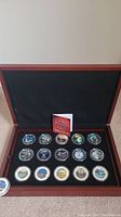 Full set of 15 Canadian provincial proof coins in wooden display box with black velvet lining and collection booklet.
