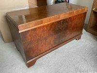 Full view of heirloom cedar chest showing rectangular shape, wood grain veneer, and flat top surface.