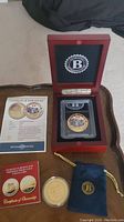 Overall lot with both 24K gold plated Bradford Exchange coins, certificates of authenticity, display box, protective cases, and blue drawstring pouch
