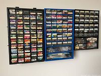 Wide view of three wall-mounted organizing cabinets filled with labeled drawers containing embroidery floss in various colors